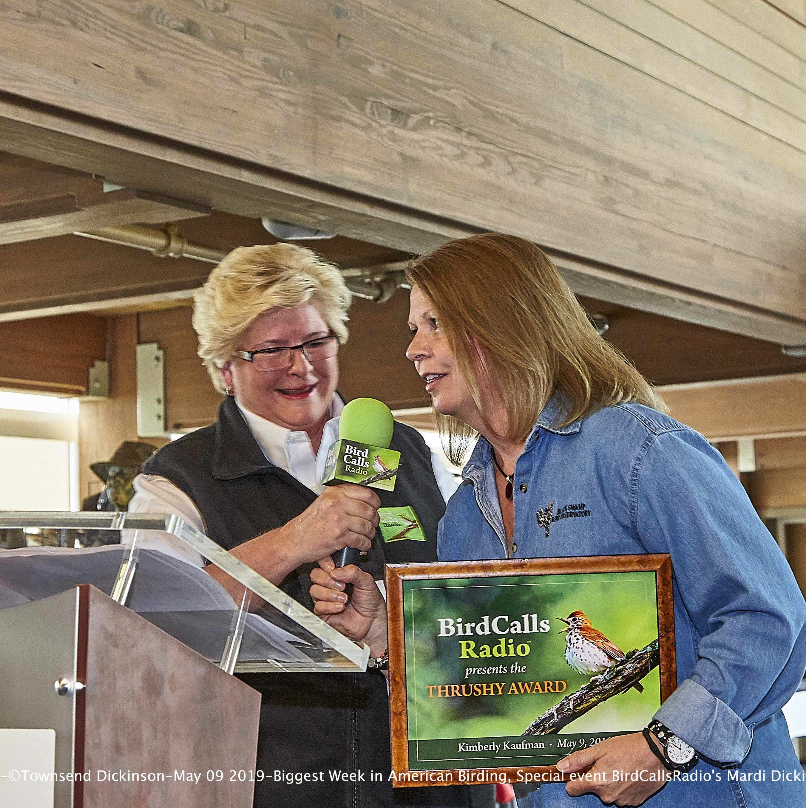 BirdCallsRadio's Mardi Dickinson presents Inaugural "Thrushy Award" to Kimberly Kaufman, BSBO Executive Director at the Biggest Week in American Birding 2019 10th Anniversary on May 9, 2019, Maumee Bay State Park Lodge, Oregon, Ohio. ©Townsend P. Dickinson. 